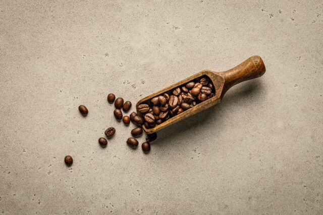 a wooden scoop filled with coffee beans